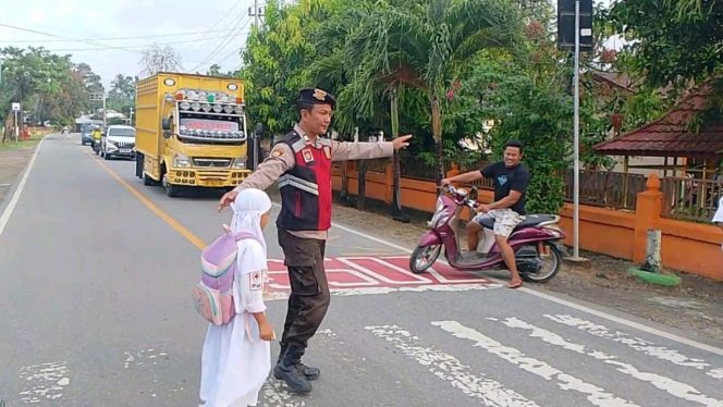 
					Anggota Polsek Tibawa Bantu Siswa SDN 10 Tibawa Menyeberang Jalan